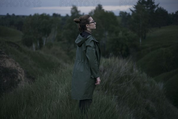 Pensive Caucasian woman standing on hill