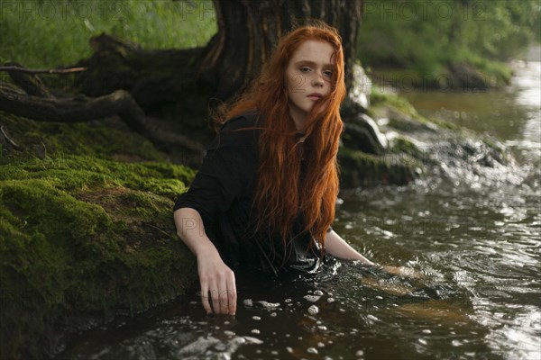 Serious Caucasian woman standing waist deep in water