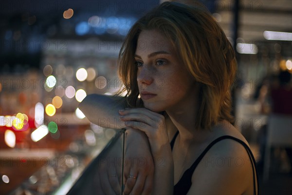 Pensive Caucasian teenage girl leaning on railing