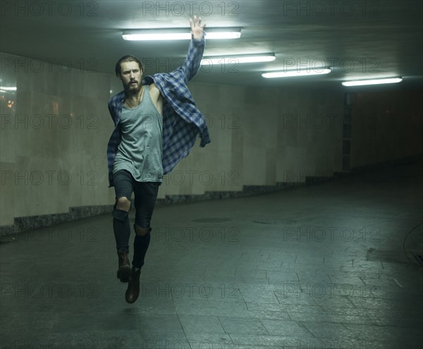 Carefree Caucasian man skipping in tunnel