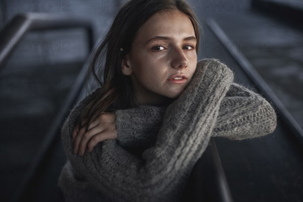 Portrait of serious Caucasian woman leaning on staircase railing