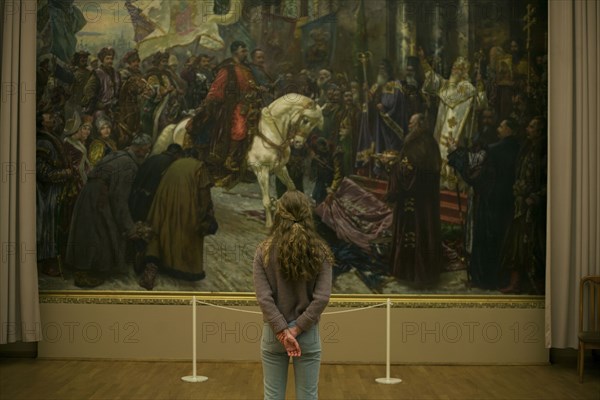 Caucasian teenage girl admiring painting in museum