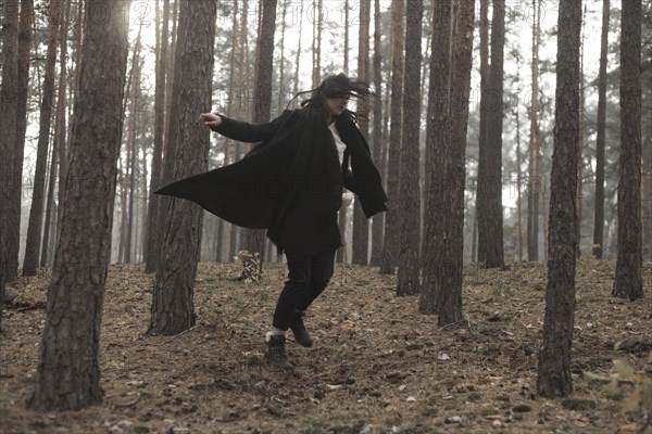 Caucasian woman dancing in forest