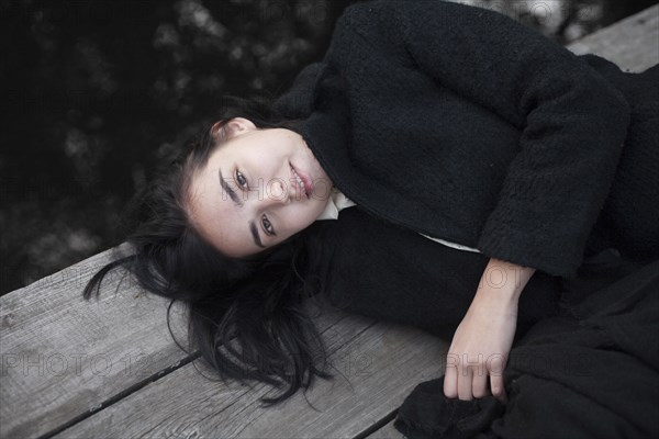 Portrait of Caucasian woman laying on wood