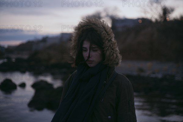 Caucasian woman wearing fur hood at ocean