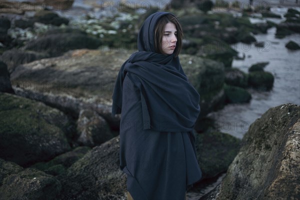 Caucasian Woman Wearing Scarf On Rocks At Ocean Photo12 Tetra Images Dmitriy Bilous