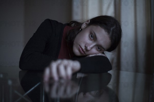 Portrait of serious Caucasian woman leaning face on arm at table