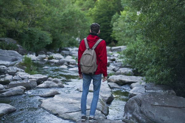 Caucasian man standing on rock in river