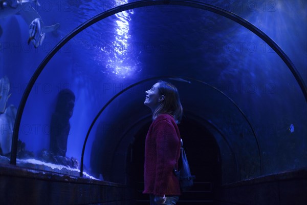 Caucasian woman admiring fish in aquarium