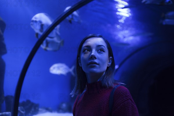 Caucasian woman admiring fish in aquarium