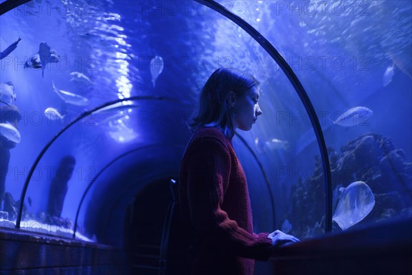 Caucasian woman admiring fish in aquarium