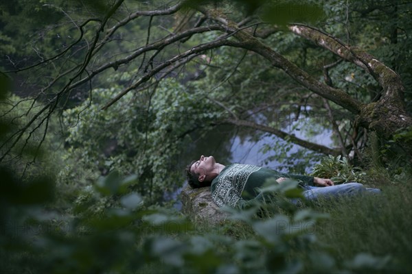 Caucasian man relaxing in woods