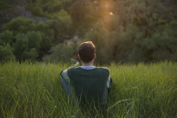 Caucasian man sitting in grass