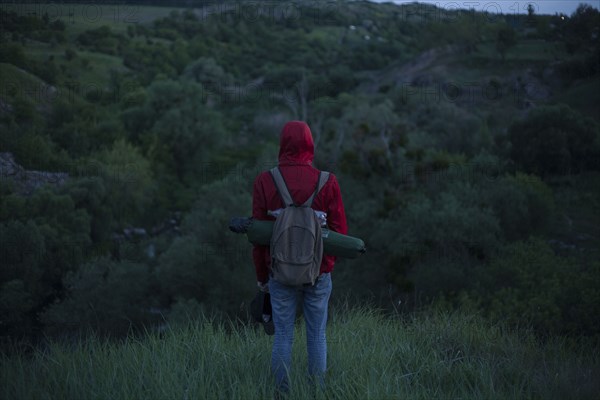 Caucasian hiker standing in grass