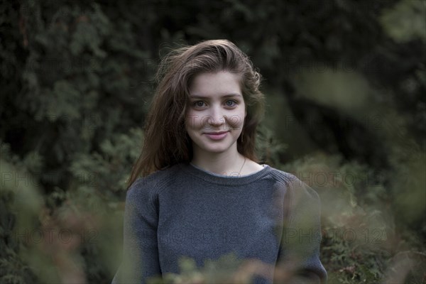 Portrait of smiling Caucasian teenage girl in woods