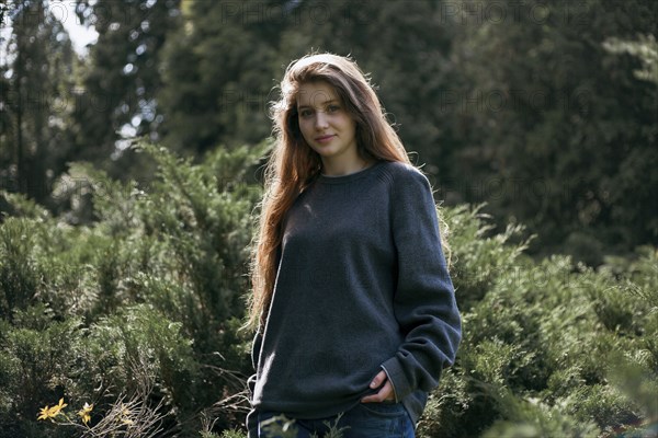 Portrait of smiling Caucasian teenage girl in woods