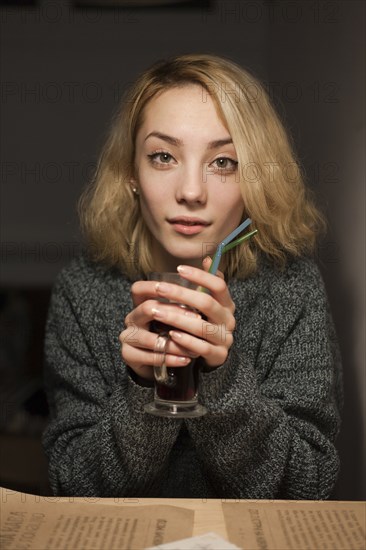 Smiling Caucasian woman warming hands holding coffee