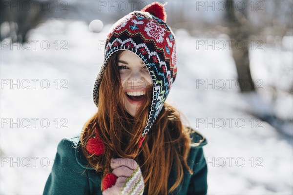 Caucasian woman playing with hat in winter