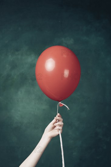 Hand holding red balloon