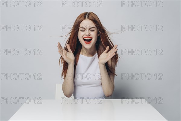 Excited Caucasian woman sitting at windy table