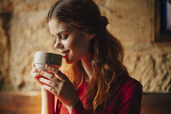 Caucasian woman sipping cup of tea