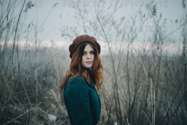 Serious Caucasian woman standing in field