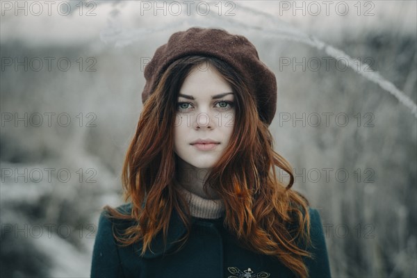 Serious Caucasian woman standing in field