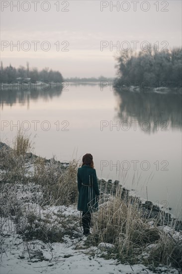 Caucasian woman standing near river in winter