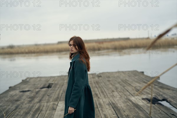 Serious Caucasian woman standing on dock