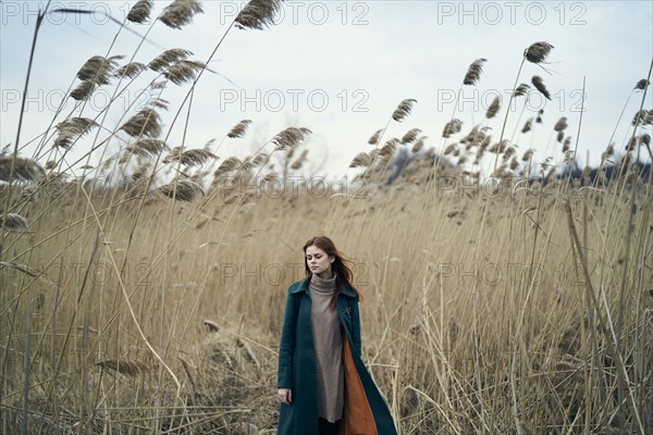 Pensive Caucasian woman standing in field