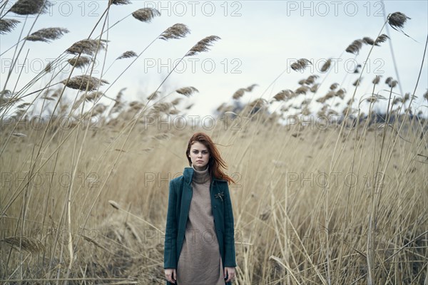 Serious Caucasian woman standing in field