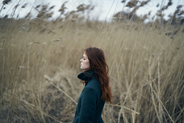 Serious Caucasian woman standing in field