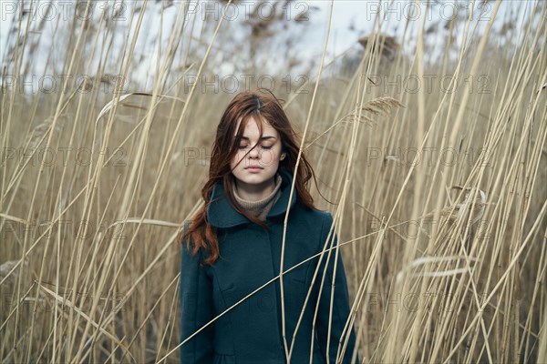 Caucasian woman standing in field with eyes closed