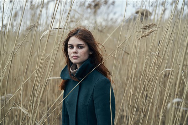 Serious Caucasian woman standing in field