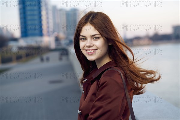 Smiling Caucasian woman at waterfront