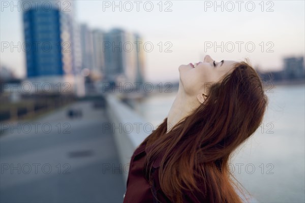 Smiling Caucasian woman at waterfront
