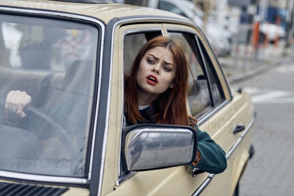 Frustrated Caucasian woman leaning on door driving car