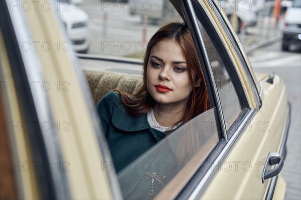 Pensive Caucasian woman in back seat of car