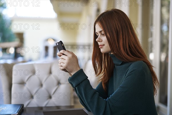 Caucasian woman texting on cell phone at restaurant
