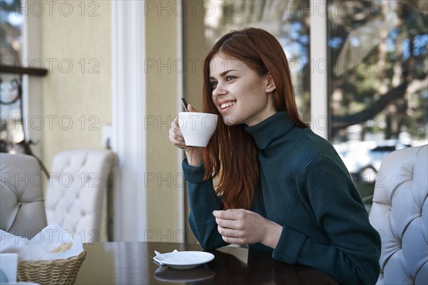 Caucasian woman drinking coffee at restaurant