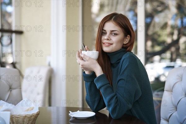 Caucasian woman drinking coffee at restaurant