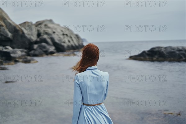 Wind blowing hair of woman at ocean