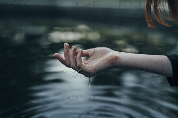 Water dripping from hand of woman