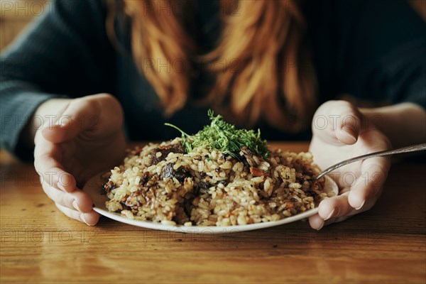 Hands of woman holding a plate of rice