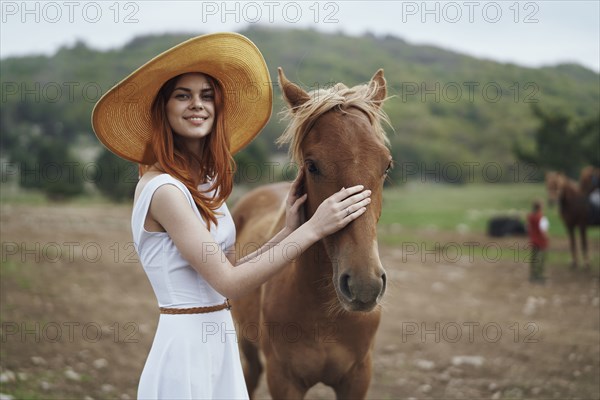 Smiling woman petting horse