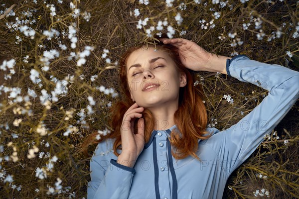 Caucasian woman laying in field of wildflowers