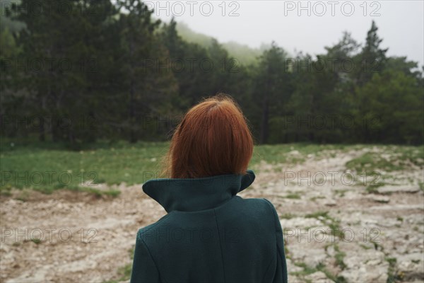 Caucasian woman wearing a coat with a collar in field