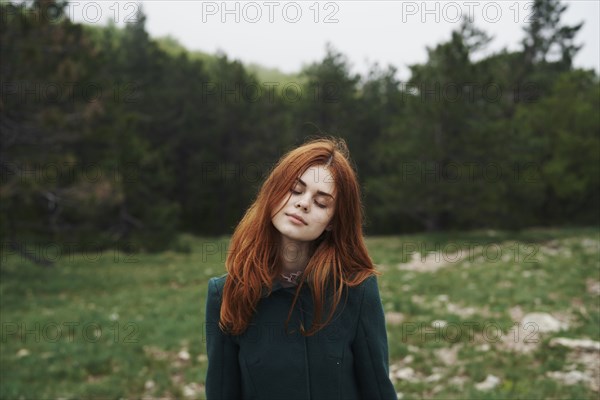 Caucasian woman wearing coat in field