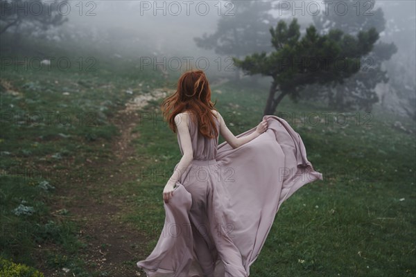 Caucasian woman wearing a dress in field