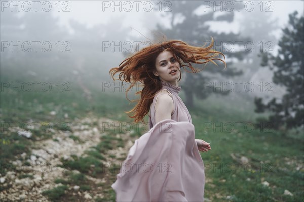 Caucasian woman tossing hair in field